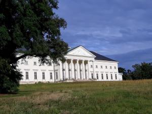 un grand bâtiment blanc avec colonnes sur un champ dans l'établissement Studio pro 2 osoby se samostatným vstupem, à Kutná Hora