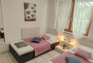 a bedroom with two beds and a window at Apartments Riba in Vis
