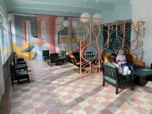 two people sitting on a couch in a room with a mural at Hotel Mures in Saturn