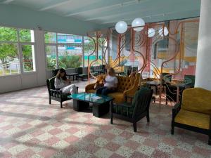 two women sitting on couches in a waiting room at Hotel Mures in Saturn