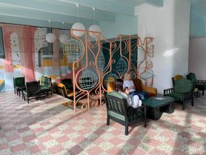 a woman sitting on a chair in a waiting room at Hotel Mures in Saturn