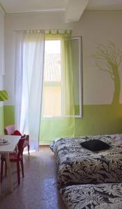 1 dormitorio con cama, ventana y mesa en Ottavo Portone, en Bolonia