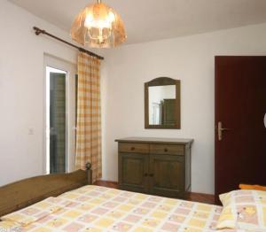 a bedroom with a bed and a mirror and a dresser at Vila Druzijanic in Brist