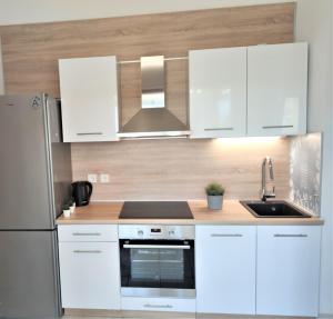 a kitchen with white cabinets and a stainless steel refrigerator at Apartments Riba in Vis