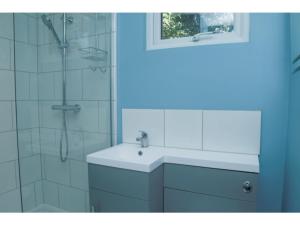La salle de bains est pourvue d'un lavabo et d'une douche. dans l'établissement StayZo - Crofton Park - Central London refurbished Studio, à Londres
