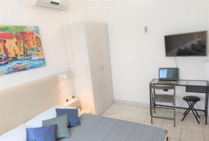 a bedroom with a bed and a desk with a television at Apartments Riba in Vis