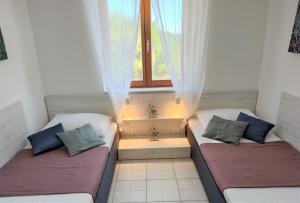 two beds in a small room with a window at Apartments Riba in Vis