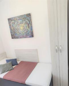 a bed in a room with a painting on the wall at Apartments Riba in Vis