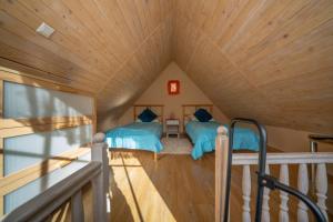 two beds in a room with a wooden ceiling at U Robsona in Szklarska Poręba