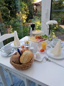 uma mesa branca com uma cesta de pão e ovos em Pension Mien Fründt em Baabe