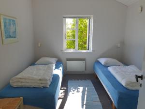 twee bedden in een kleine kamer met een raam bij Feriestedet Skovly in Klemensker
