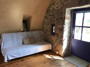 a bed in a room with a brick wall at Le gite du Larzac à Brunas in Creissels