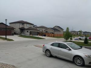 um carro prateado estacionado na entrada de uma casa em The Home Sweet Home em Winnipeg