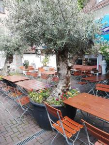 a table and chairs with a tree and some flowers at Moosburger Hof in Moosburg