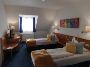 a hotel room with two beds and a desk at Moosburger Hof in Moosburg