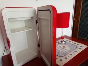 un frigorifero aperto con tavolo e lampada di Damarilù ad Alghero