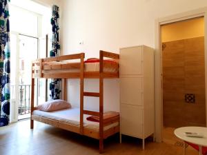 Łóżko piętrowe w pokoju z lodówką w obiekcie Hostel Mancini Naples w mieście Napoli