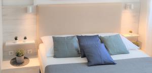 a white bed with blue pillows in a room at Apartments Riba in Vis