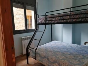 Apartaments Mitjavila في Sant Salvador de Toló: غرفة نوم مع سرير بطابقين وسلم إلى سرير بطابقين