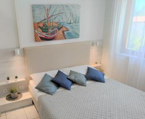 a bedroom with a bed with blue pillows at Apartments Riba in Vis