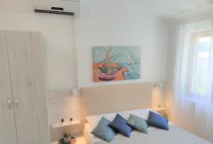 a bedroom with a bed with blue pillows at Apartments Riba in Vis