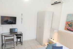 a living room with a table and a desk with a television at Apartments Riba in Vis