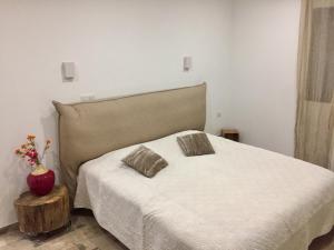 a bedroom with a white bed with two pillows on it at Casa Serena in Cuttoli-Corticchiato