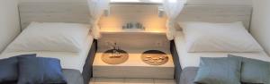 a bedroom with two beds with white pillows at Apartments Riba in Vis