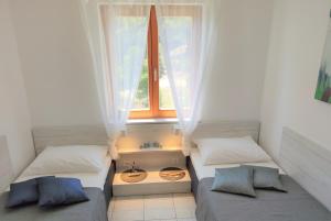 two beds in a room with a window at Apartments Riba in Vis