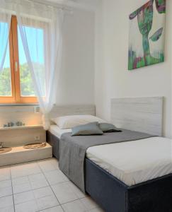 two beds in a bedroom with a window at Apartments Riba in Vis