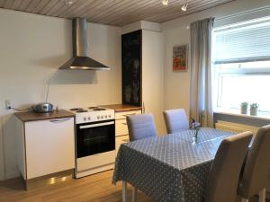 cocina con mesa y cocina con fogones en Hyggelig ferielejlighed en Skagen