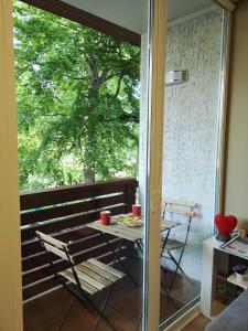 een tafel en stoelen op een balkon met een boom bij Rise and Shine apartment in Juodkrantė