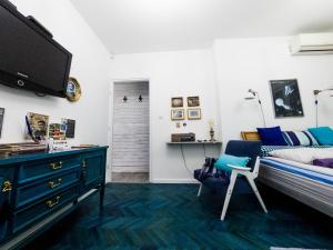 a bedroom with a bed and a tv and a chair at Apartment Tesla Wizard in Belgrade