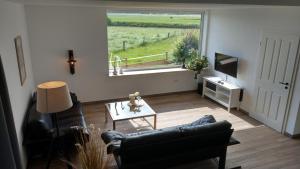 a living room with a couch and a table and a window at Im Alten Stall in Loxstedt