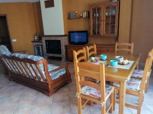 a living room with a table and chairs and a television at Apartaments Mitjavila in Sant Salvador de Toló