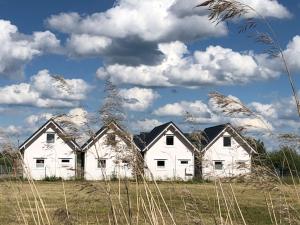 a group of white houses in a field at Merinn in Rogowo