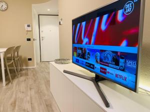 a large flat screen tv on a white stand in a living room at Rivacentro in Riva del Garda