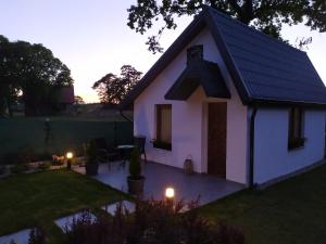 a small white house with a patio in a yard at Eko Dolina Kluki in Kluki +8 photos