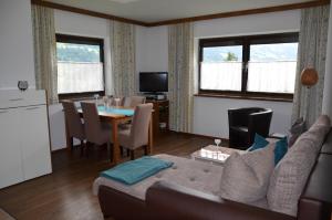 a living room with a couch and a table at Gästehaus Wildauer in Schlitters