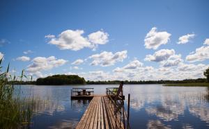 - un quai en bois avec une table de pique-nique sur un lac dans l'établissement Brīvdienu māja Ezera Sonāte, à Bērzgale 2 autres photos