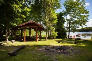 un belvédère et un foyer à côté d'un lac dans l'établissement Brīvdienu māja Ezera Sonāte, à Bērzgale