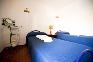 a bedroom with two blue beds in a room at Villino Fraginesi in Castellammare del Golfo