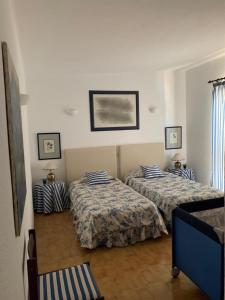 a bedroom with two beds and a picture on the wall at Casa Camelia in Vilamoura