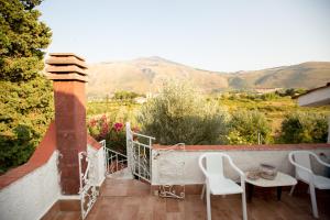 a balcony with a table and chairs and mountains at Villino Fraginesi in Castellammare del Golfo