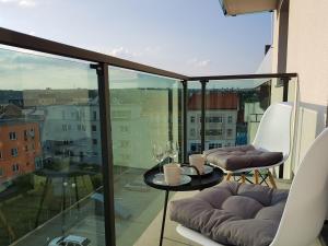d'un balcon avec une table et des chaises et une vue. dans l'établissement KaVi Apartments #1, TOP sunset view, à Plzeň