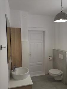 a white bathroom with a sink and a toilet at Freiraum in Flensburg +7 photos