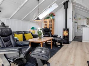 Bøtø Byにある6 person holiday home in V ggerl seのリビングルーム(テーブル、革張りの椅子、暖炉付)