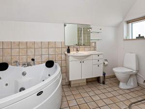 ein Badezimmer mit einer Badewanne, einem WC und einem Waschbecken in der Unterkunft 6 person holiday home in V ggerl se in Bøtø By