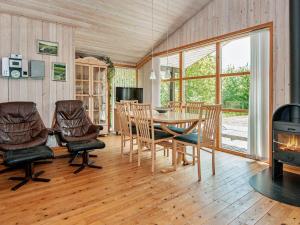 een eetkamer met een tafel en stoelen en een open haard bij 6 person holiday home in Ebeltoft in Femmøller