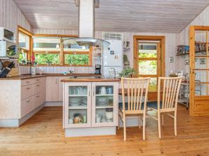 a kitchen with a counter and two chairs and a table at 6 person holiday home in Ebeltoft in Femmøller